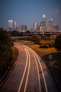 A vertical, long exposure shot of a highway in Charlotte city at night