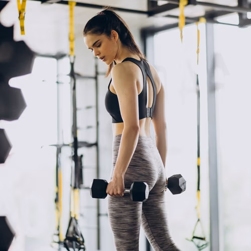 Young female trainer exercising at the gym
